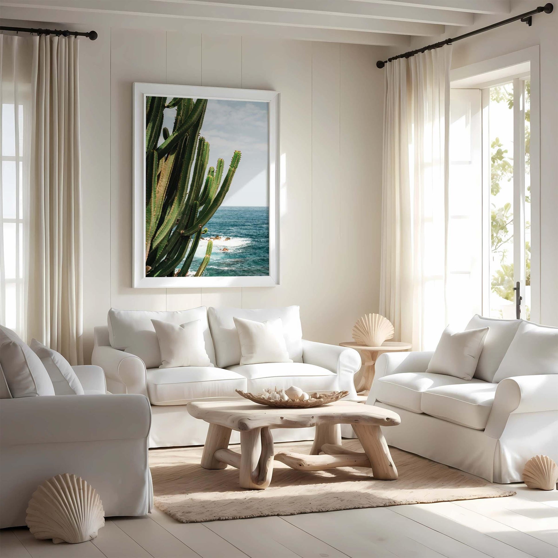 Bright living room with white sofas, wood table, and Coastal Cactus wall art; sunlight fills the space.