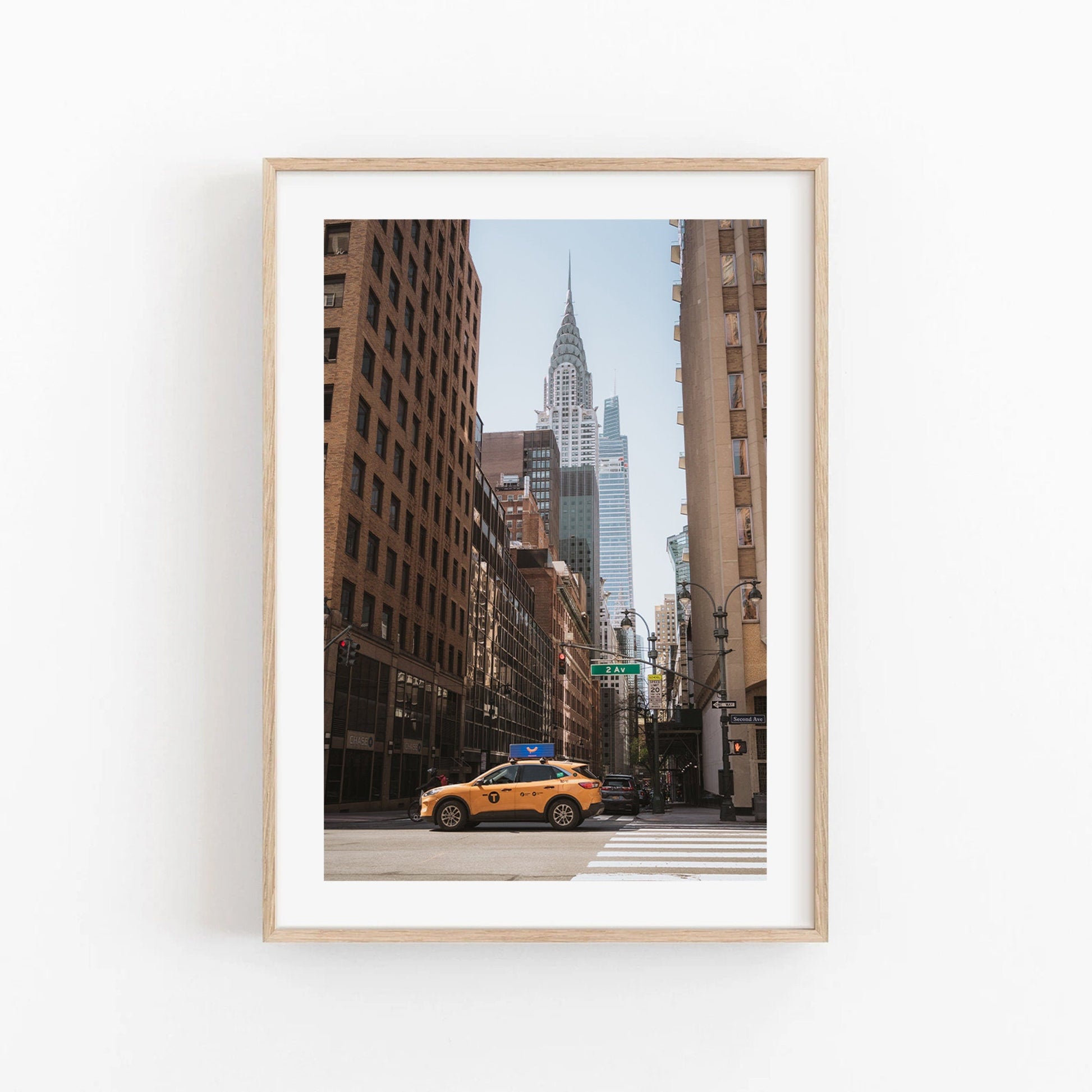 The Concrete Jungle framed photo captures a NYC street with a yellow taxi and the Chrysler Building towering above.