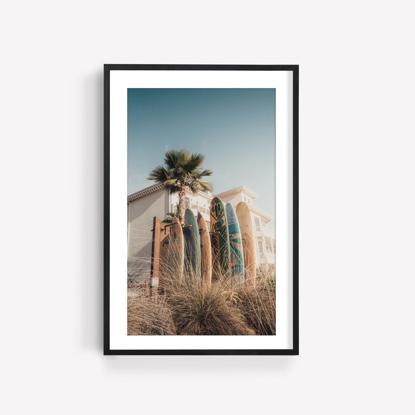 Framed Coronado Surfboards photo: surfboards by a beach house with palm trees and grasses in the sun.