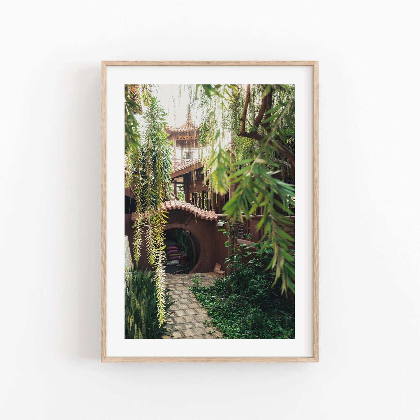 Earthy Enlightenment: Framed photo of a garden path leading to an archway under a treehouse with hanging greenery.