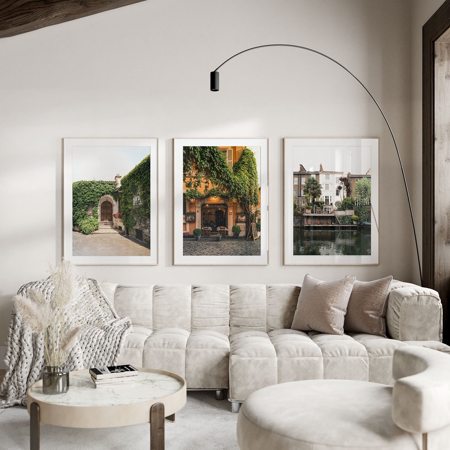 Modern living room with a cream sofa, round coffee table, and the European Charm - Set of 3 framed on the wall.