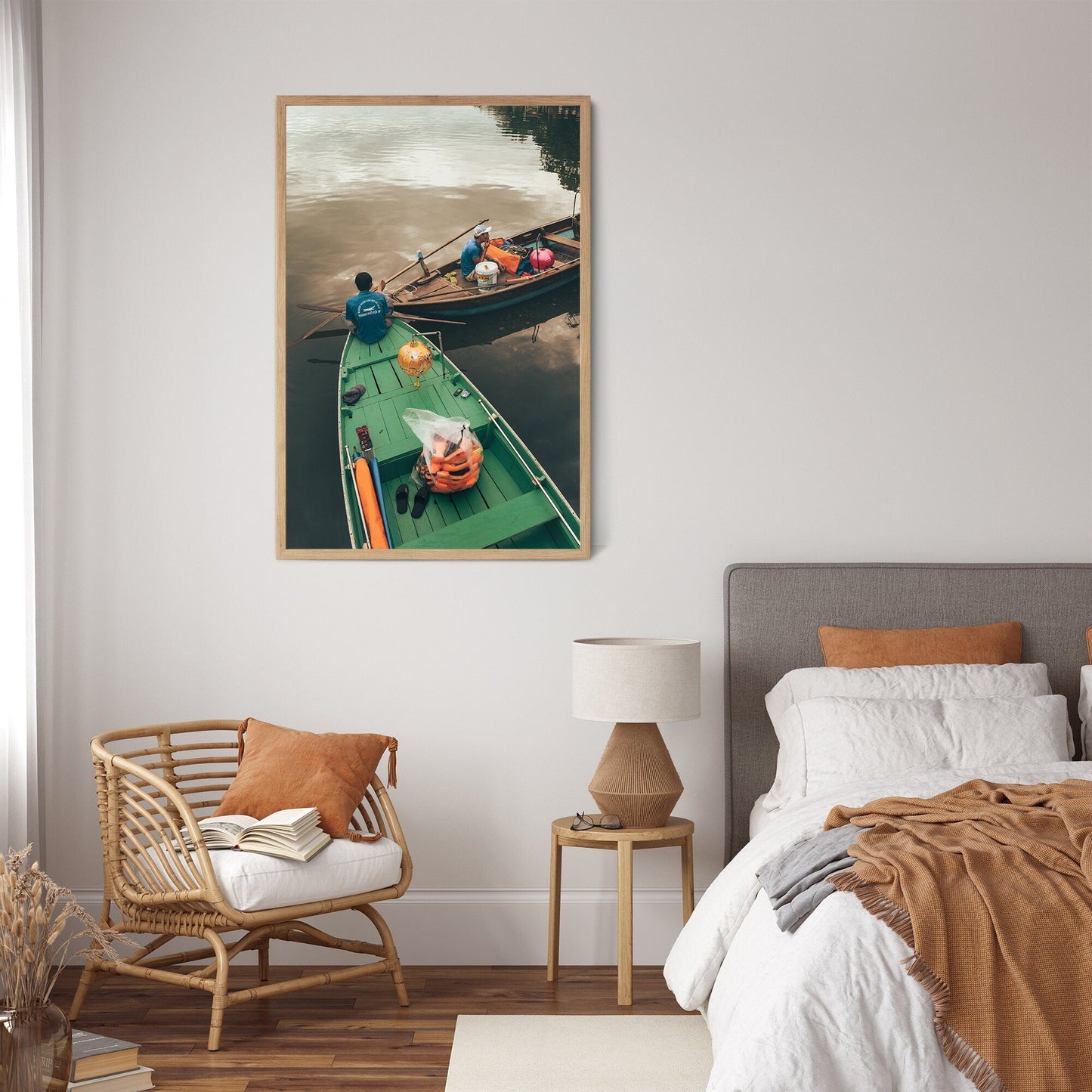 A cozy bedroom with a wicker chair, neutral decor, and the Evening Shift boating photo framed on the wall.