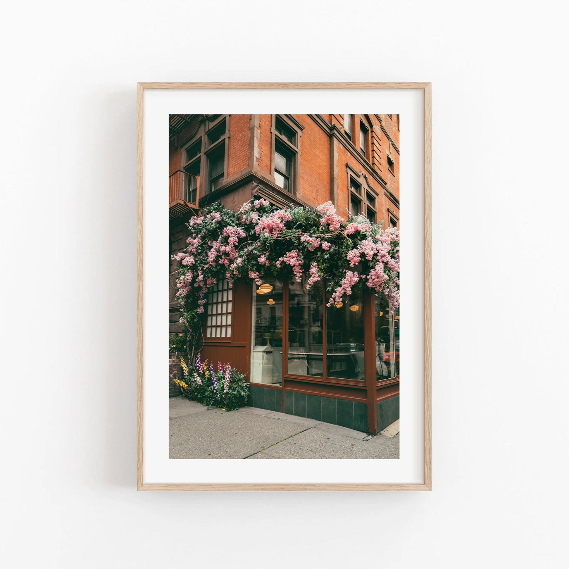 Framed Floral Cafe photo of a storefront adorned with blooming pink flowers.