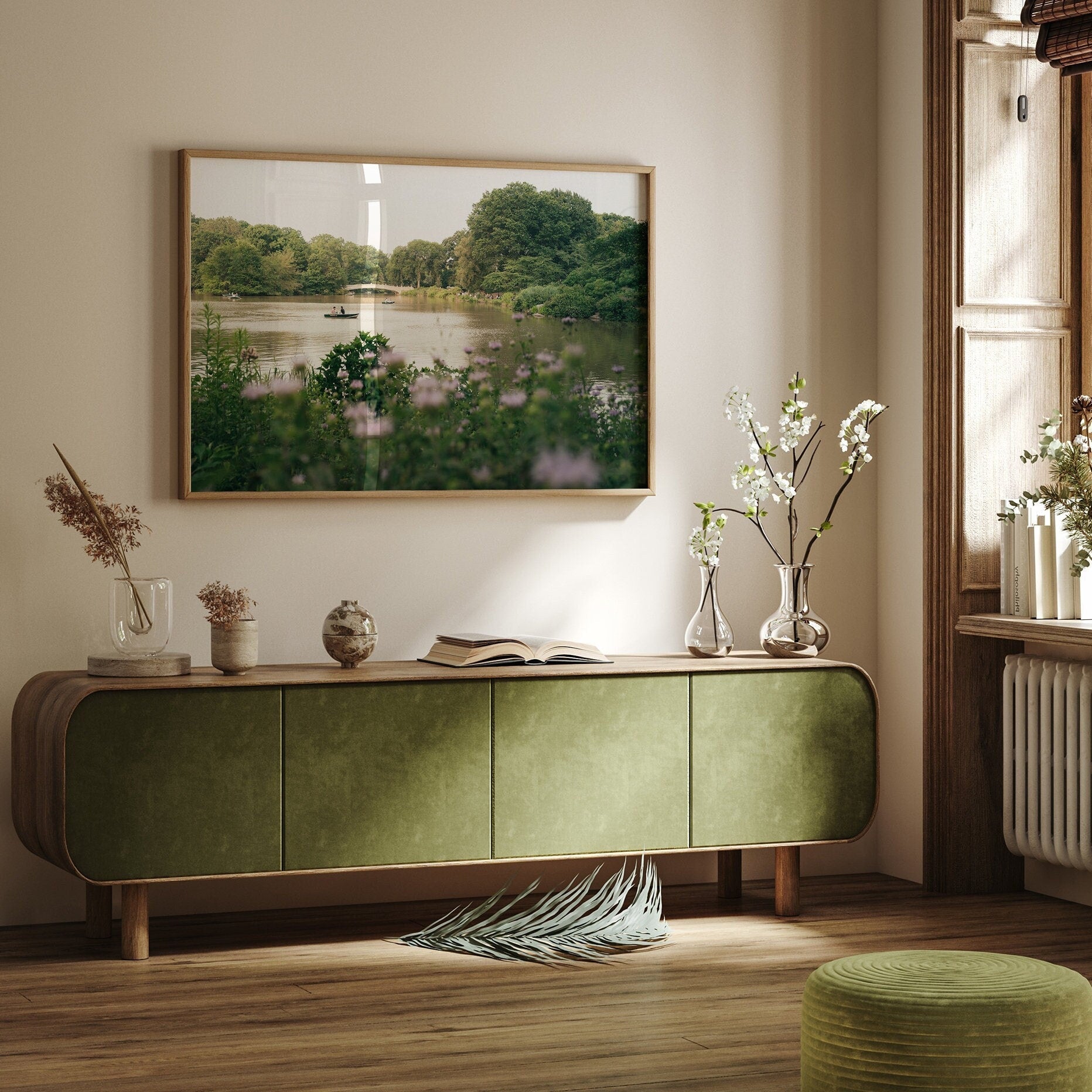 A serene living room with Golden Glide furniture, nature artwork, flower vases, and sunlight filtering through a window.