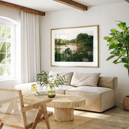 Cozy living room with the Golden Glide sofa, wooden table, plant, and framed landscape art on the wall.