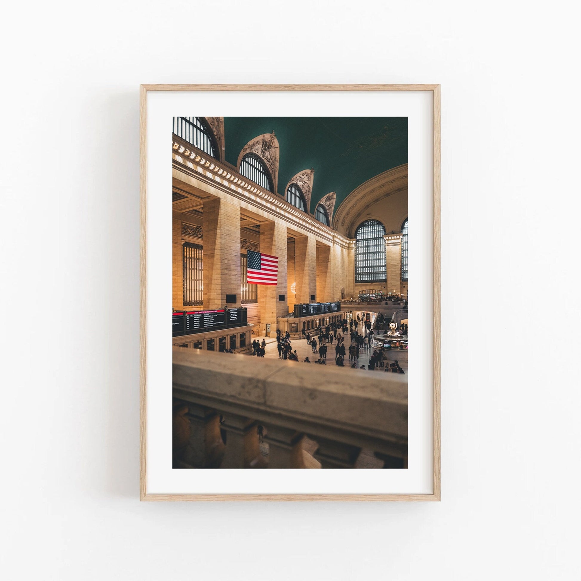 Framed photo of Grand Central showing an American flag in the hall with people below.