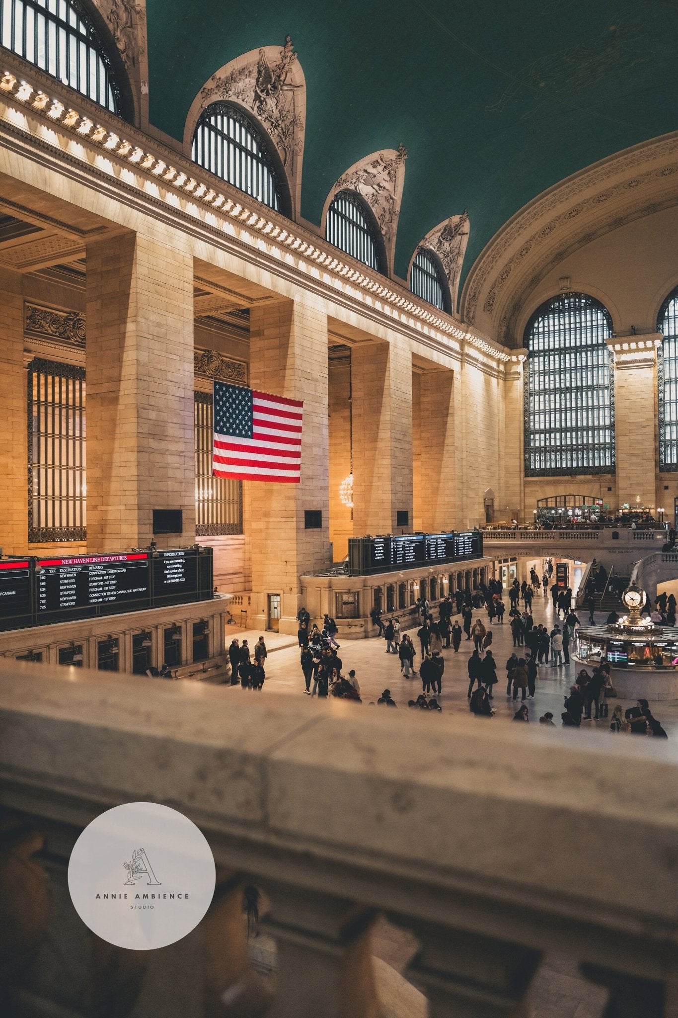 Grand Centrals interior features a U.S. flag, bustling crowd, and glowing info boards.