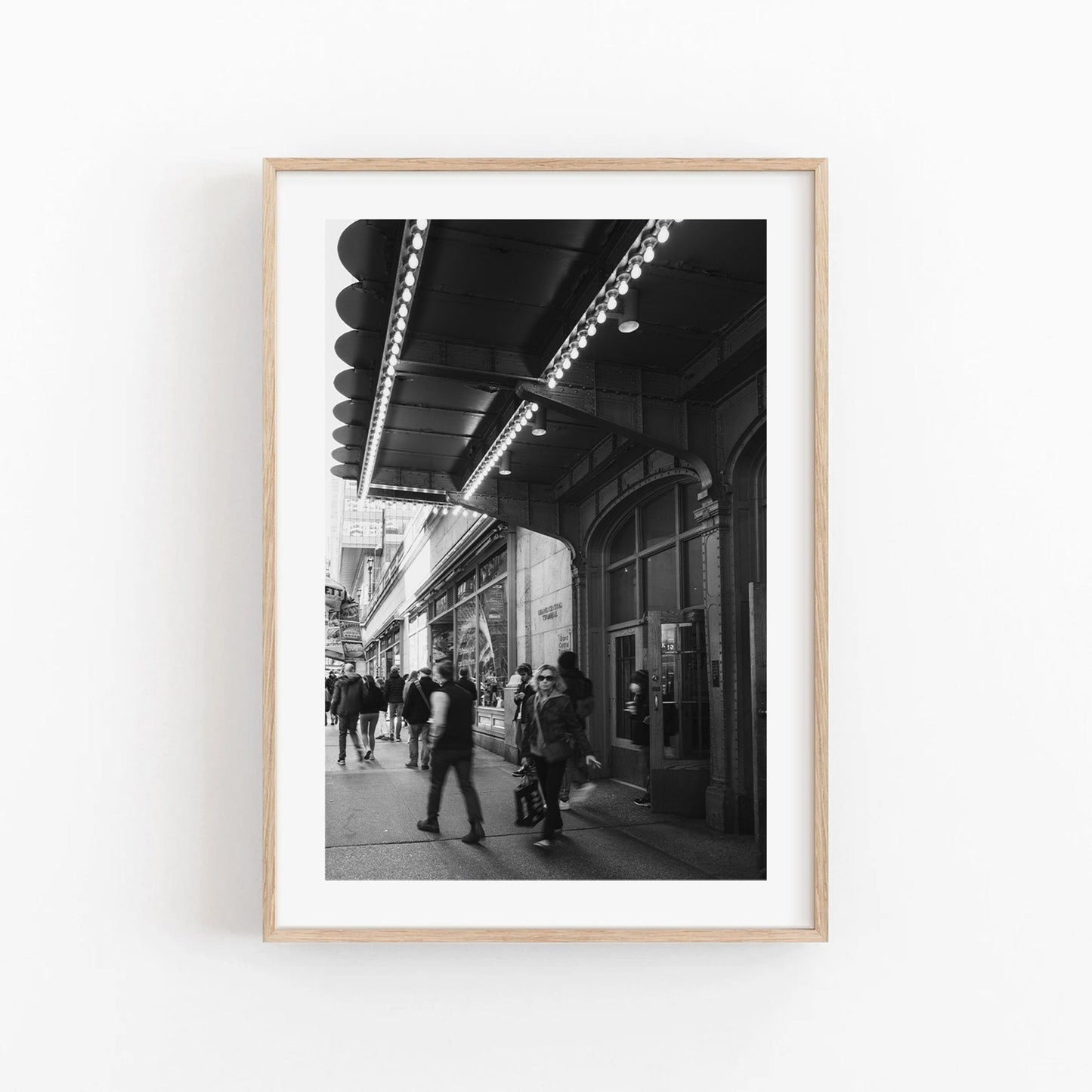 Black and white Grand Central Rhythm photo: people under an awning in a city, framed in light wood.