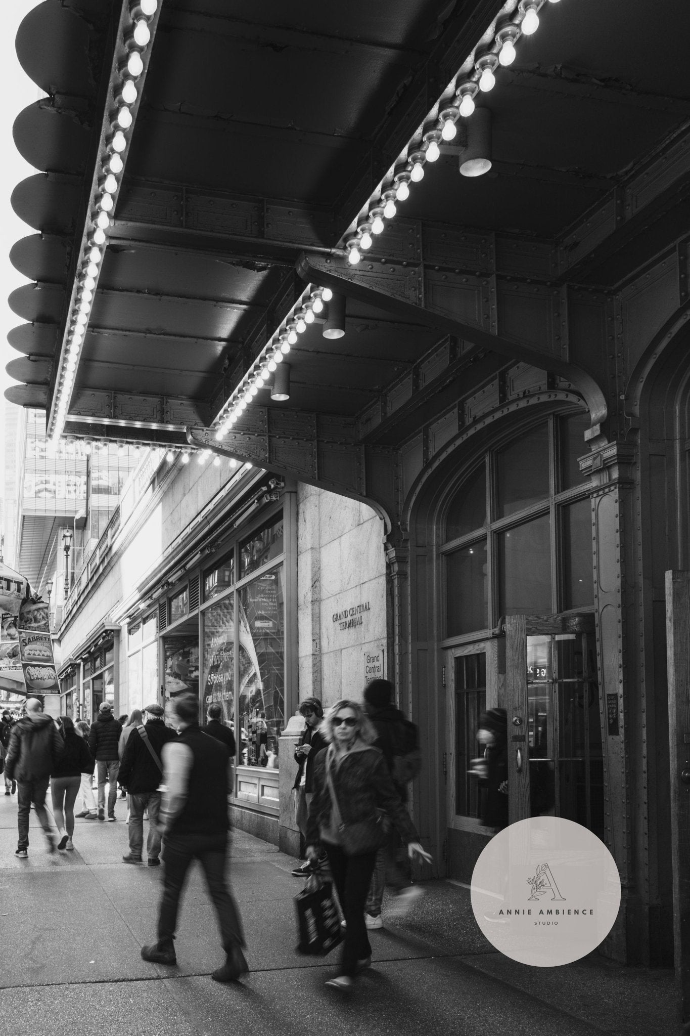 City scene under a theater marquee with lights, featuring Grand Central Rhythm Black and White.