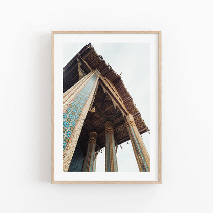 Framed Grand Palace II photo of intricate temple columns against a cloudy sky backdrop.