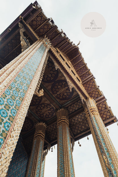 A low-angle view of Grand Palace II, featuring intricate mosaic columns and a decorative roof against a cloudy sky.