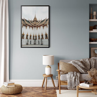 Cozy living room with a beige sofa, wooden chair, lamp, and Grand Palace VI framed on a light blue wall.