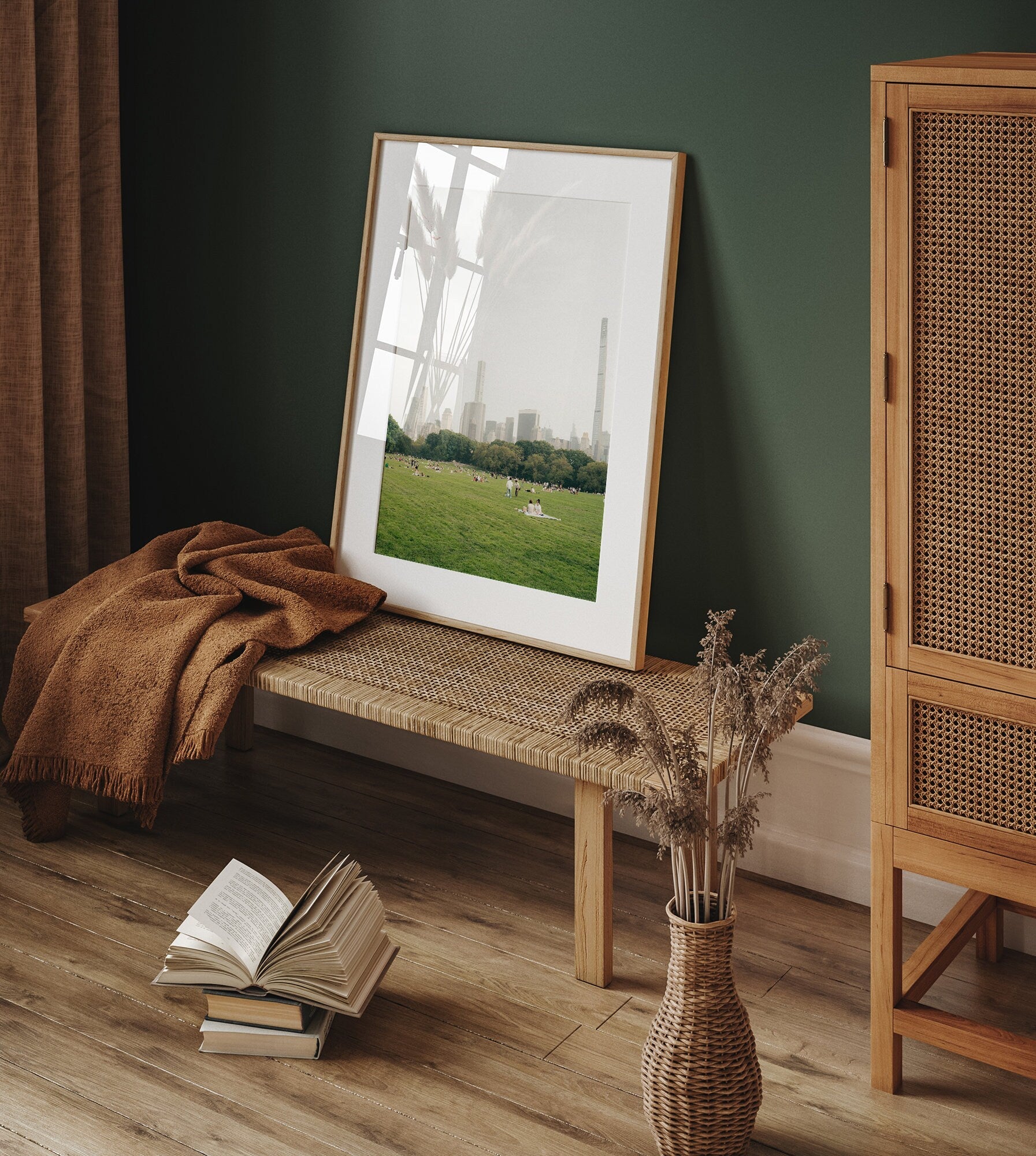 A cozy room featuring the Great Lawn II bench, framed photo, open book, blanket, and vase on a wooden floor.