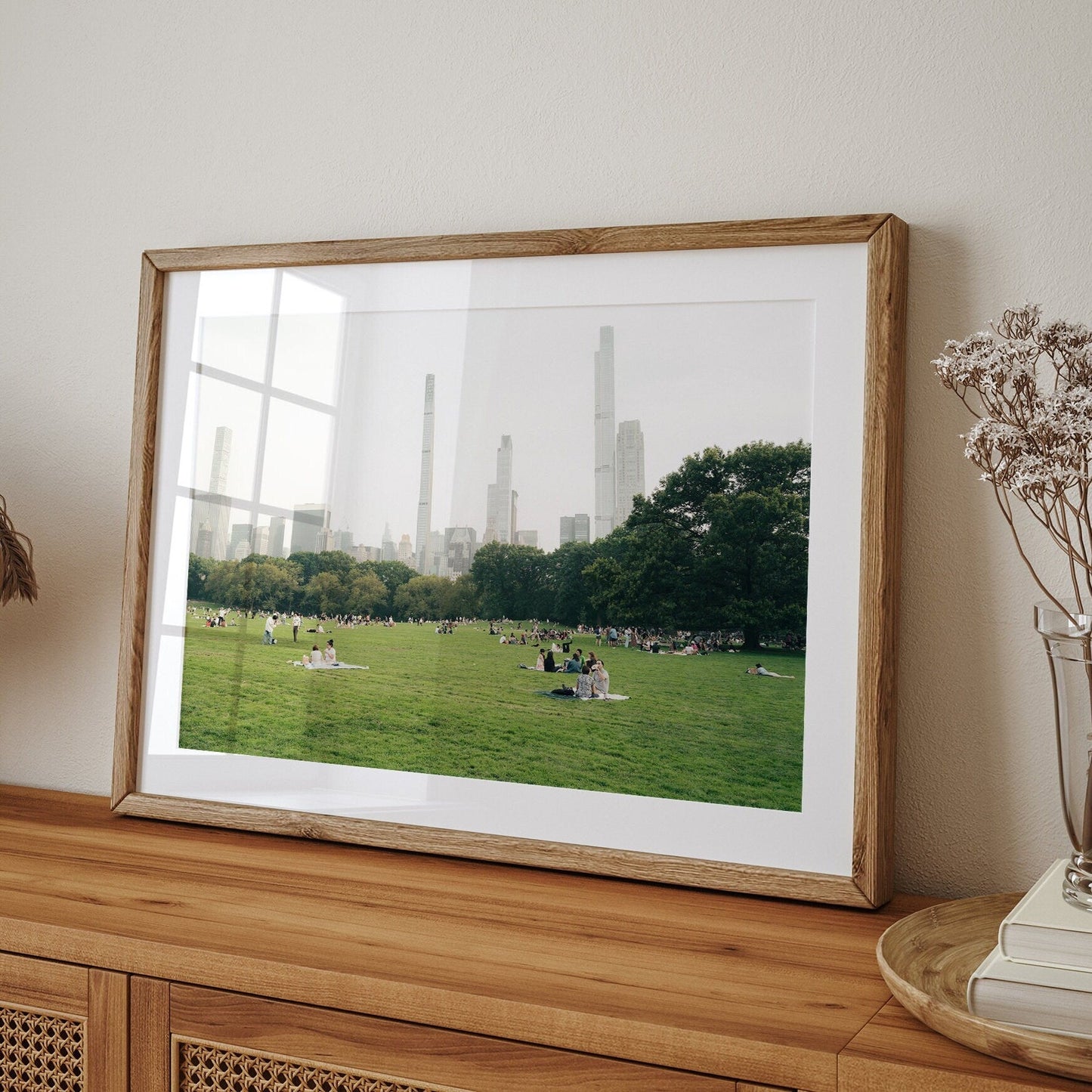 Framed photo Great Lawn on a table shows a park with people and city buildings in the background.