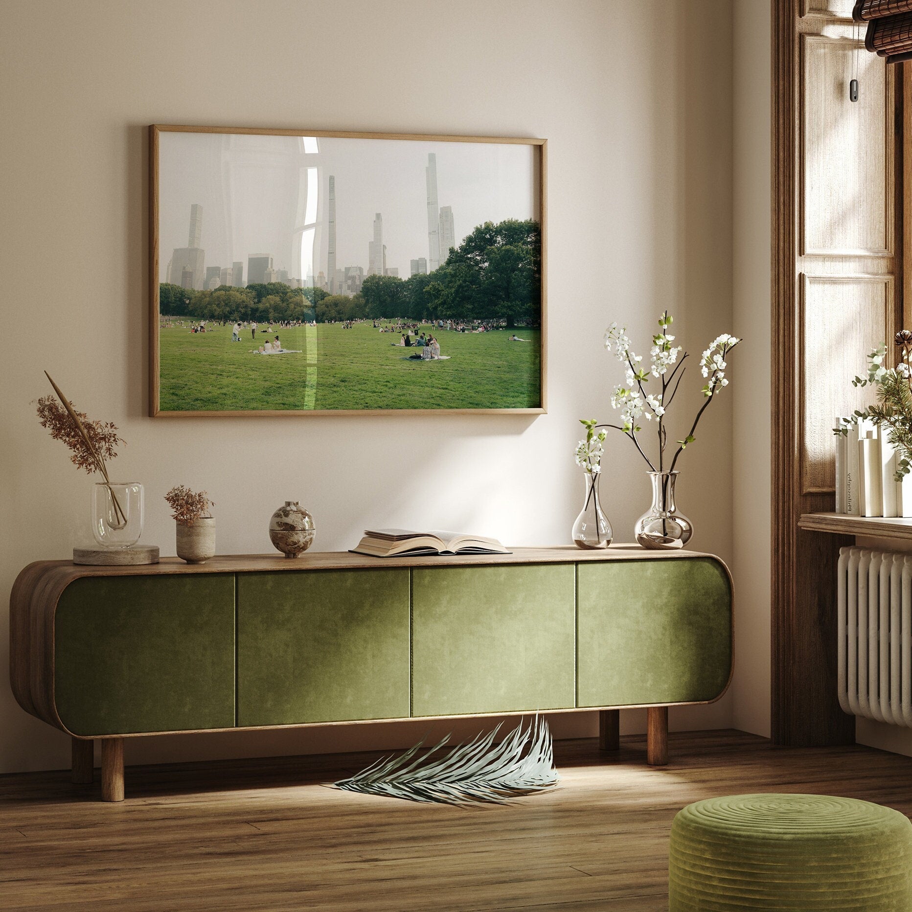 Cozy room with a Great Lawn sideboard, plants, an open book, and a cityscape photo on the wall.