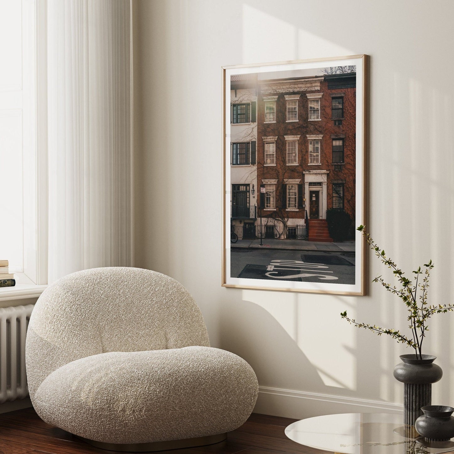 Cozy room with the Grove Street armchair, a framed urban photo, and a side table with a small plant.