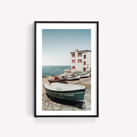 Framed photo Guethary: boats on a stone dock with white buildings and blue sky by the sea.