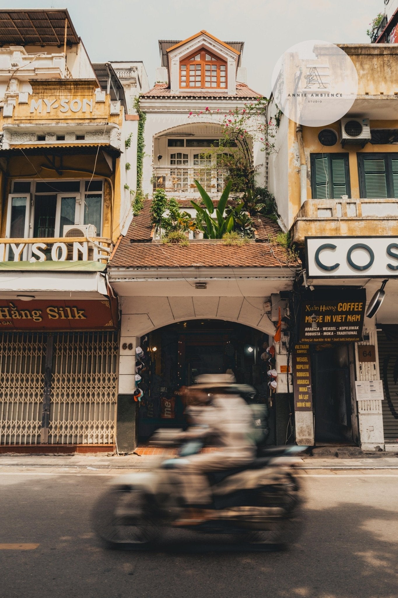 Motorbike speeds past narrow, tall buildings in lively city—Hanoi Streets - Set of 3.