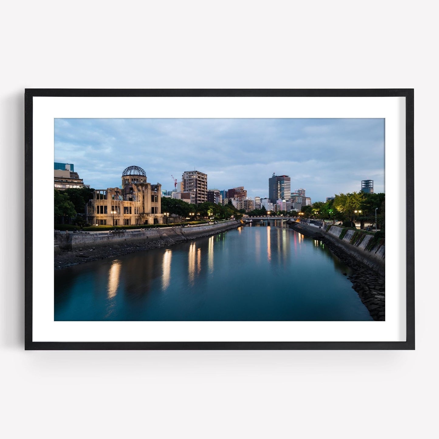 Framed photo of the Hiroshima Peace Memorial with a river and city skyline at dusk.