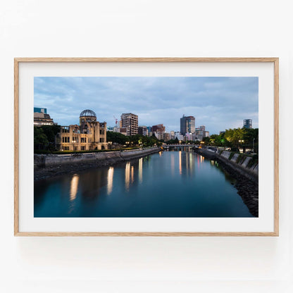 Framed photo titled Hiroshima Peace Memorial showcasing the Peace Memorial Park and river at dusk with a city skyline backdrop.