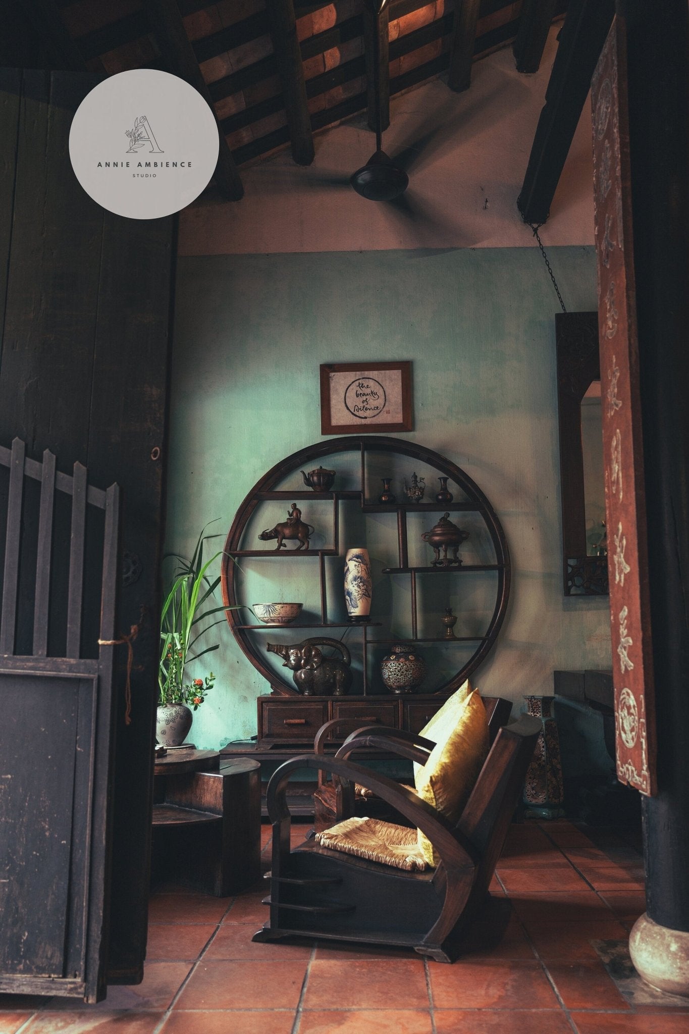 Cozy space featuring Hoi An Tea Shop round wooden shelf, plants, vases, and armchair with a yellow cushion.