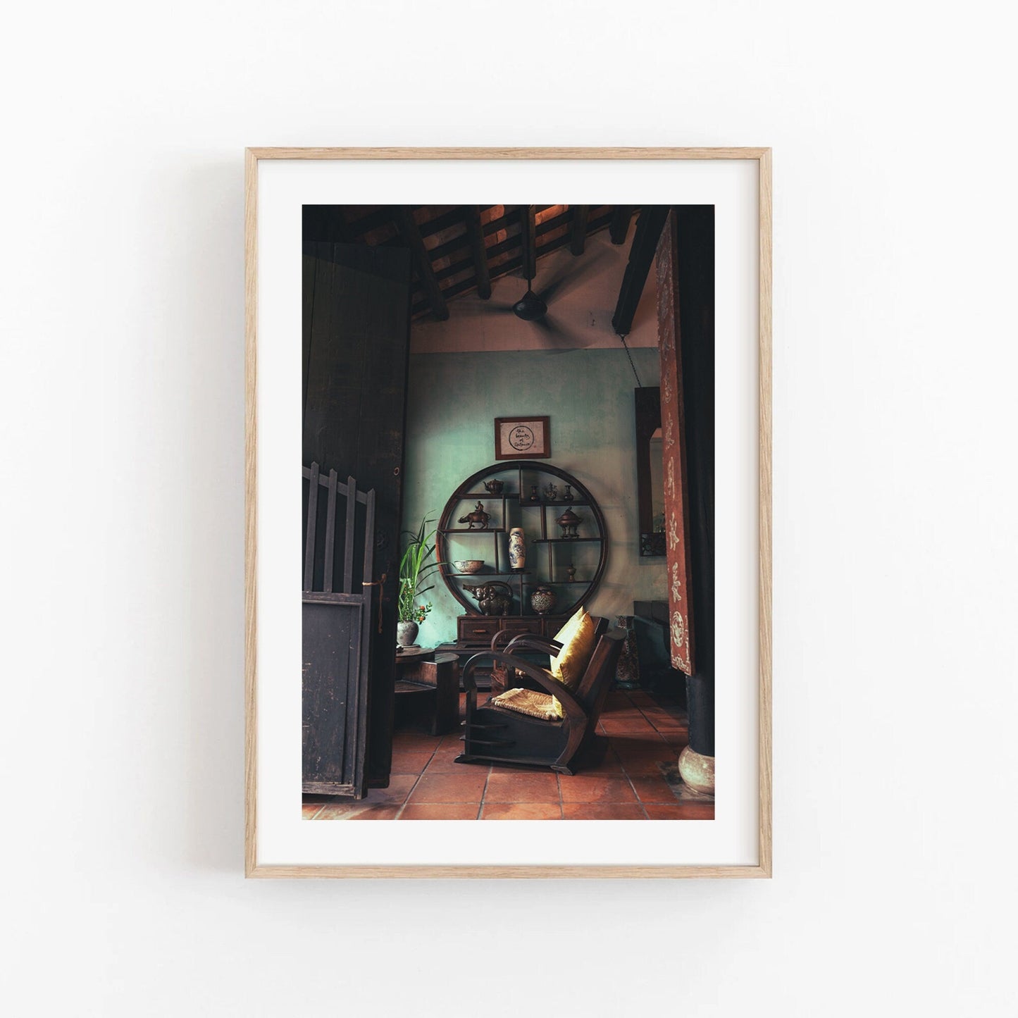 Framed photo of Hoi An Tea Shop showing a cozy room with a circular shelf, armchair, and traditional decor.