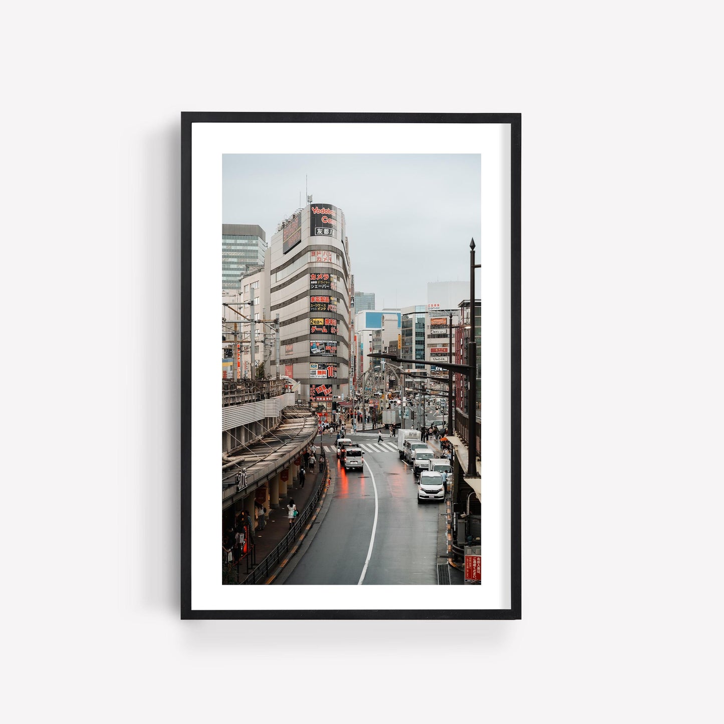 Ueno Cityscape features a top-view framed photo of Tokyos bustling streets, buildings, and traffic on a gray day.