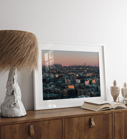 Skyline From Brooklyn photo displayed on a wooden table with a rustic lamp and decor.