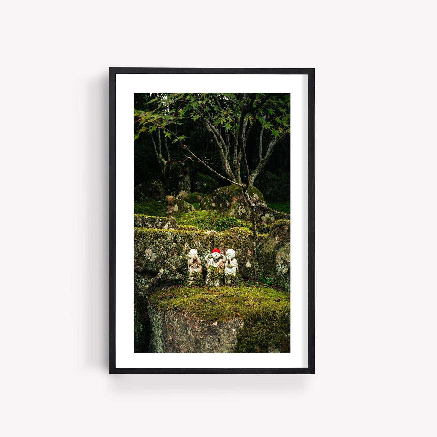 Framed Japanese Lush - Set of 3: small stone statues on mossy rocks with trees in the background.