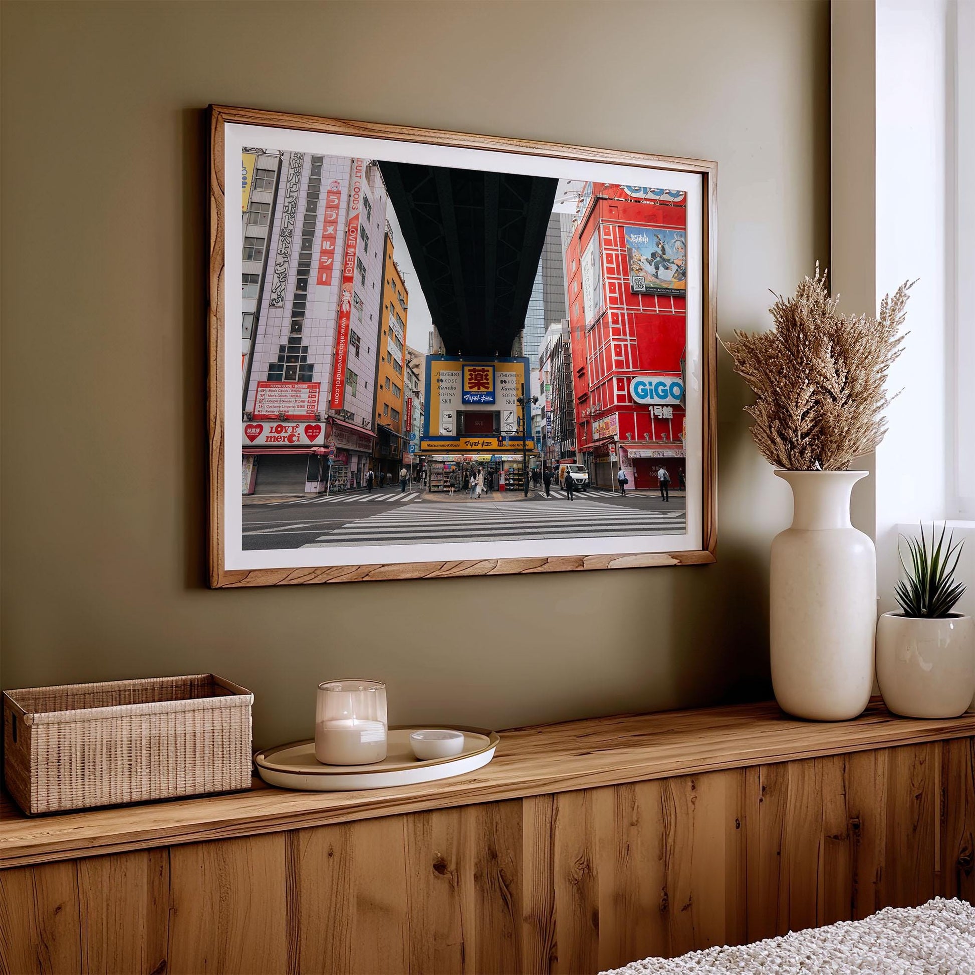 A framed photo named Akihabara hangs above a wooden console adorned with decorative items.