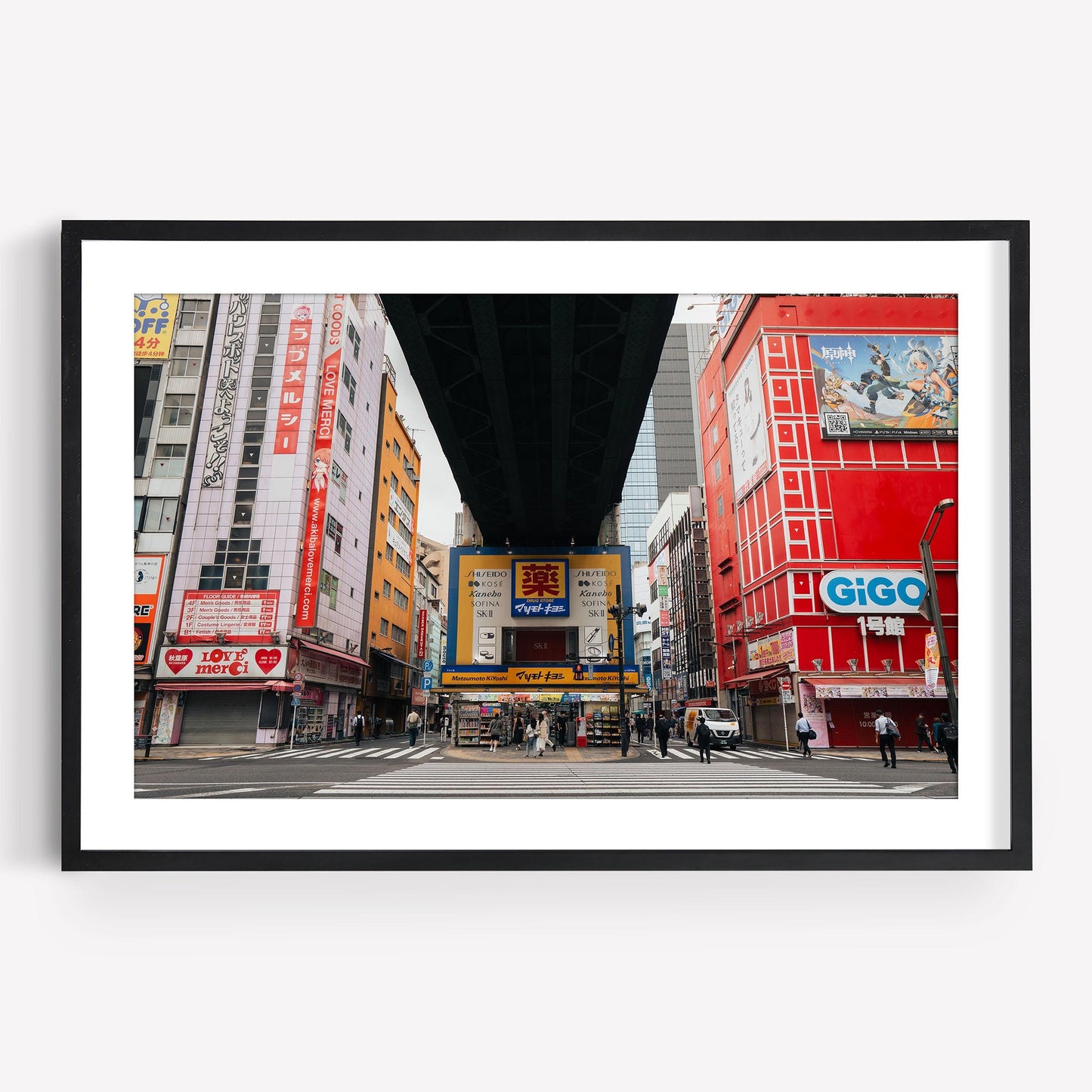 Framed city street scene from Akihabara showcasing colorful buildings, including GiGO, with an overhead structure.