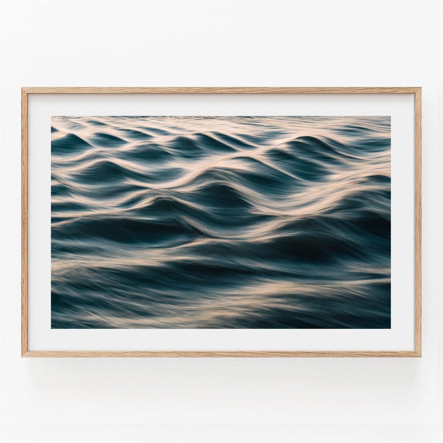 Silk Waves: Gentle ocean waves with golden sunlight, framed in light wood against a white wall.