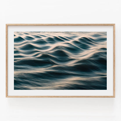 Silk Waves: Gentle ocean waves with golden sunlight, framed in light wood against a white wall.