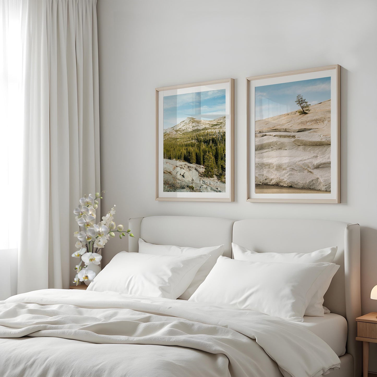 A cozy bed with white bedding under the Sierra Stillness - Set of 2 framed photos, beside a window with white curtains.