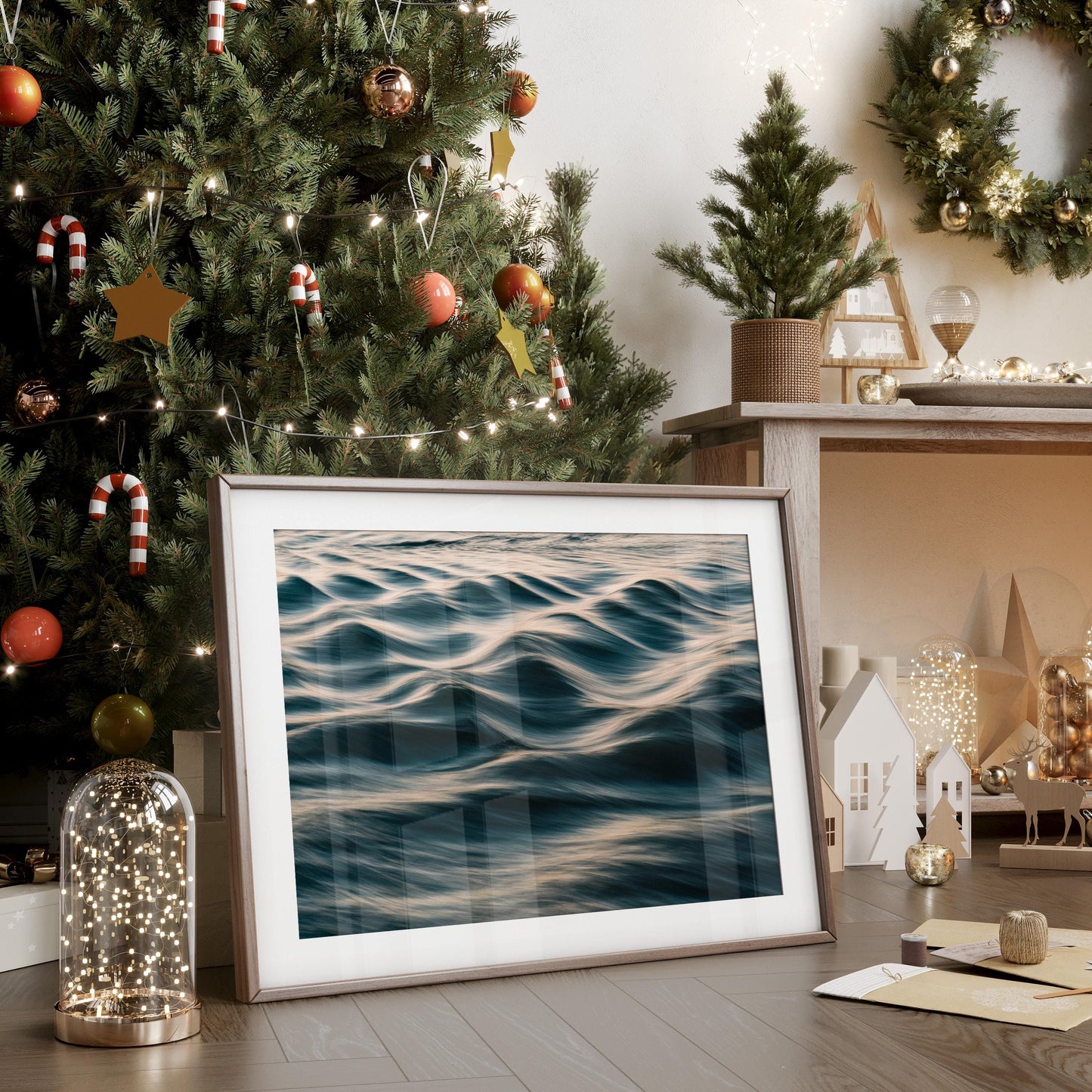 Silk Waves" ocean photo framed, displayed on floor by decorated Christmas tree with fairy lights and holiday decor.
