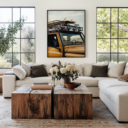 Modern living room with white sectional sofa, wood coffee tables, and “Surf Roadtrip” wall art.