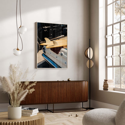 Modern living room with wooden sideboard, “Vintage Surf Ride” wall art, round mirror, and window with stacked books.