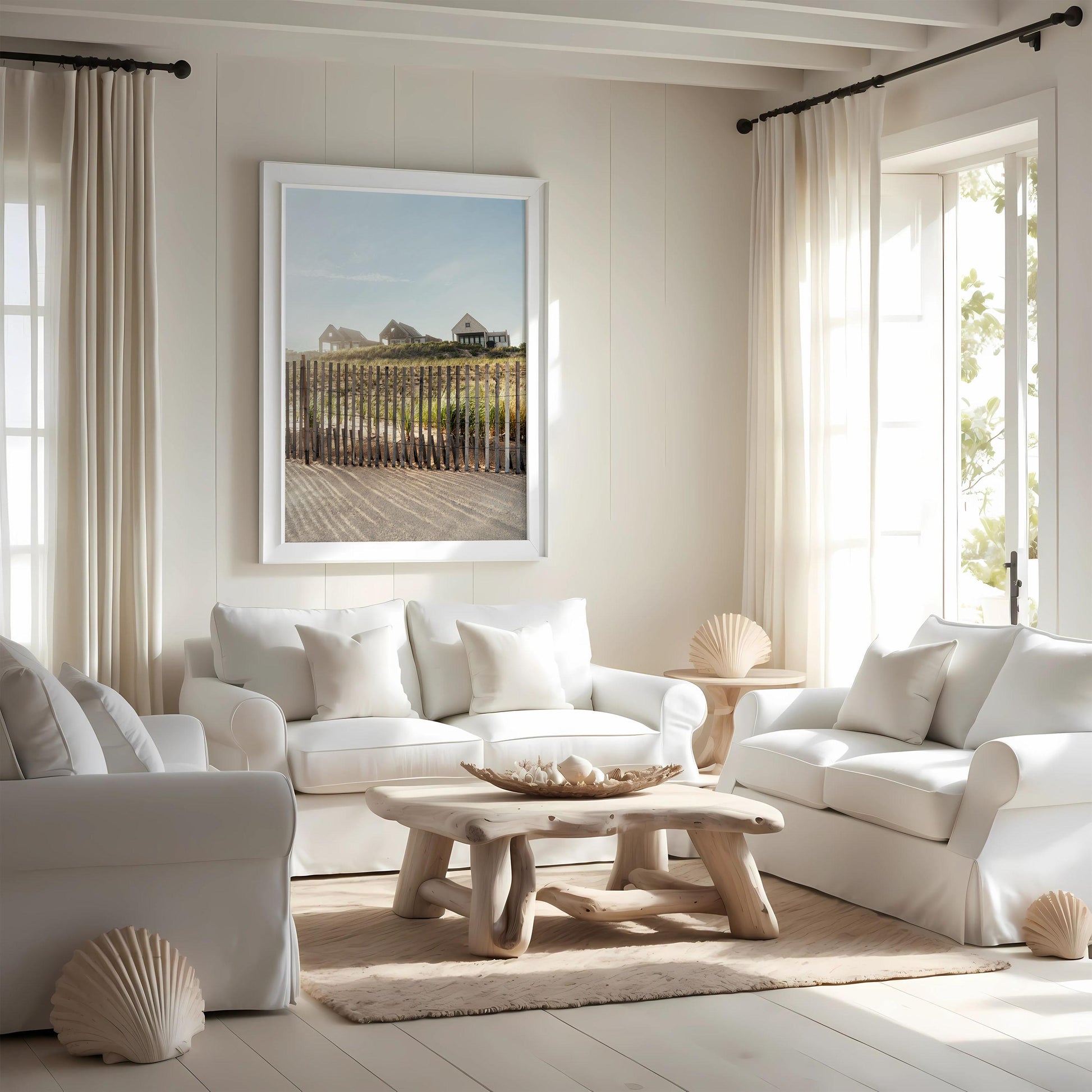 Cheerful living room with Summer Homes sofas, wood table, seashells, beach photo; sunlight fills the space.