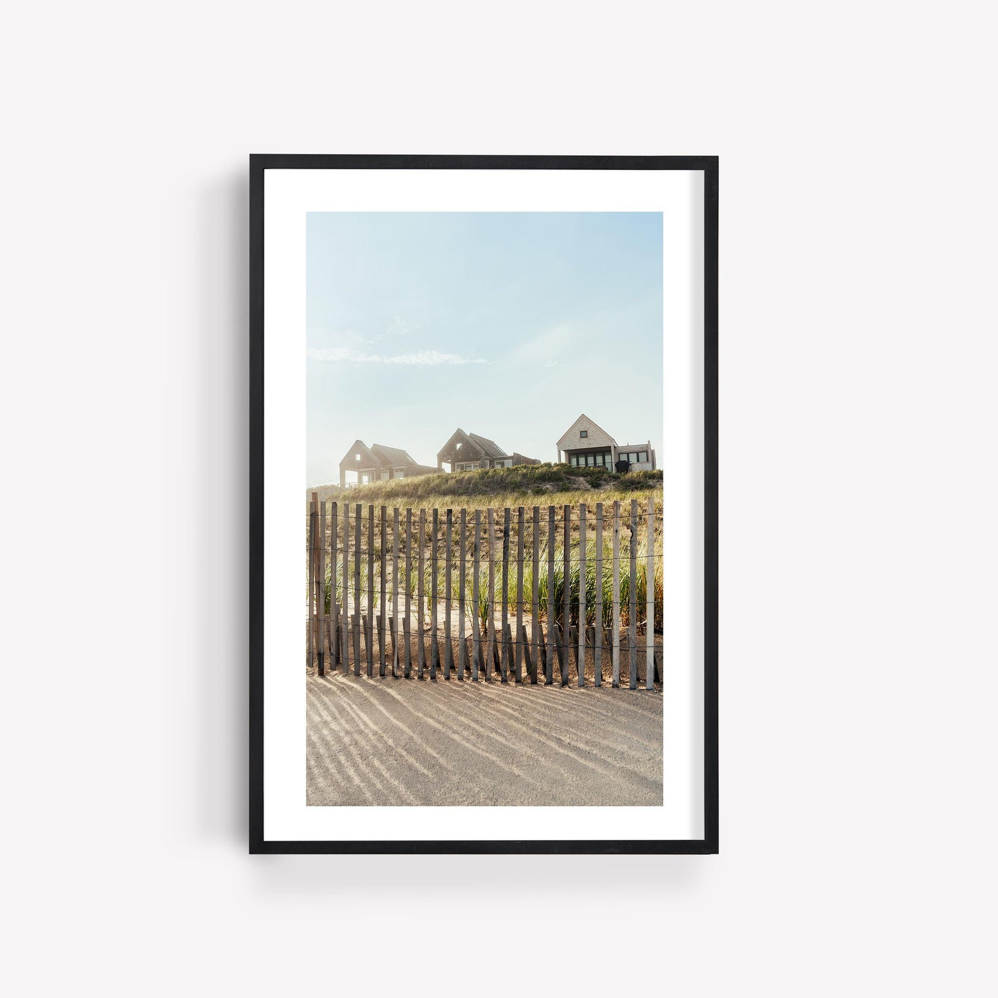 Framed photo, “Summer Homes”: coastal houses on a grassy hill behind a fence beneath a clear sky.