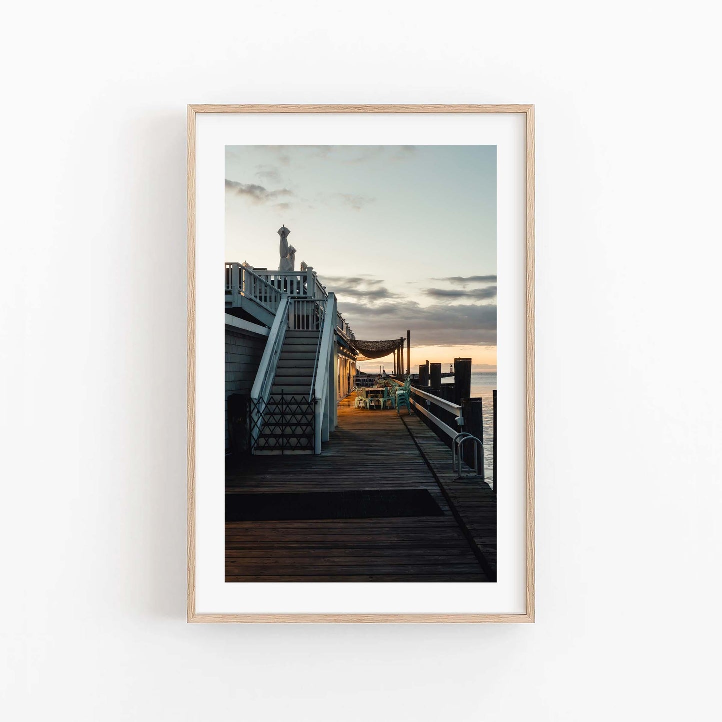 Dockside Evening: Framed photo of a wooden dock at sunset with stairs, railings, and tranquil water in the background.