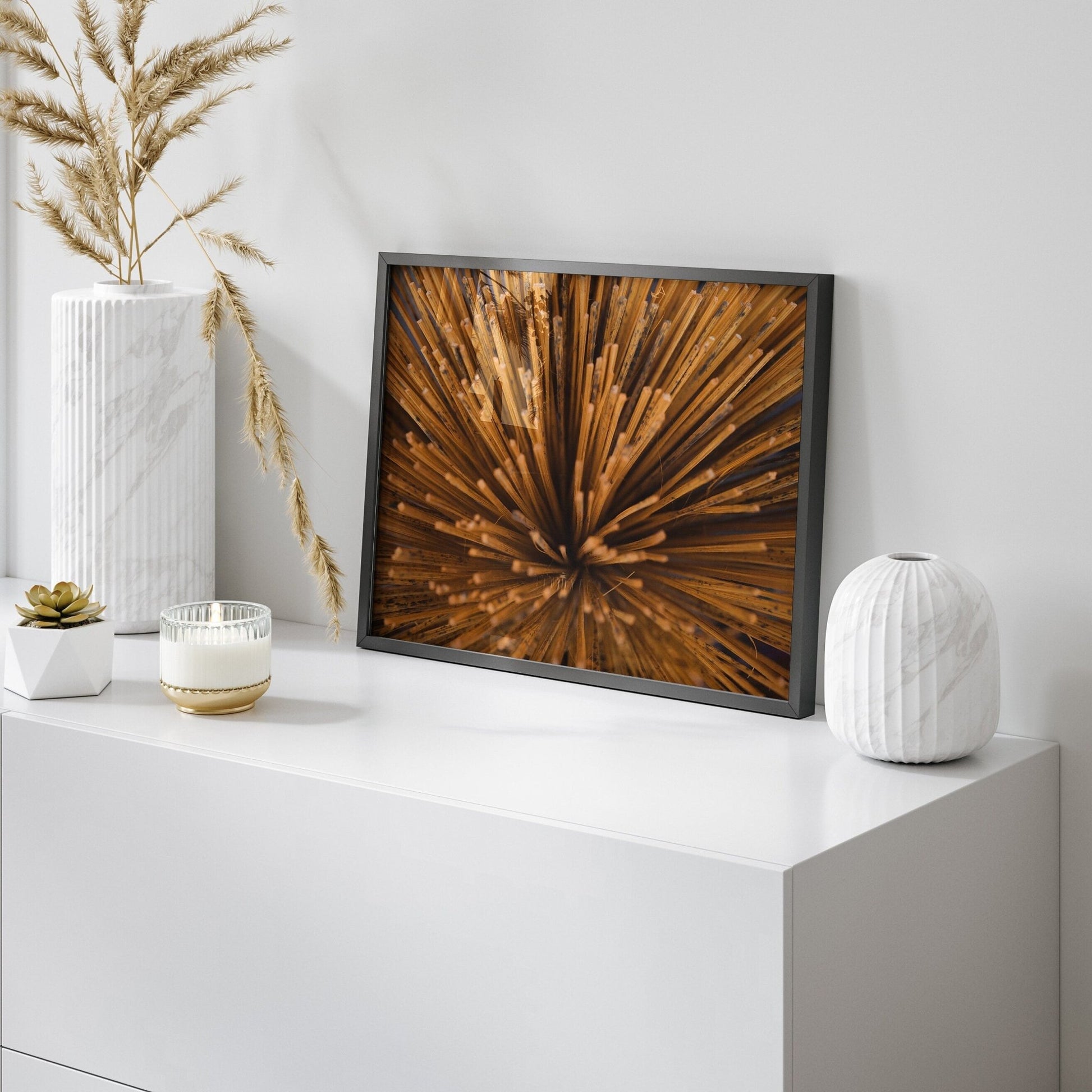 Incense on a modern white shelf with vases and candles, accented by framed abstract art and wooden spikes.