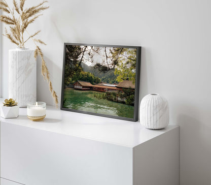 Itsukushima Shrine I photo framed and displayed on a white cabinet with vases and a small plant.