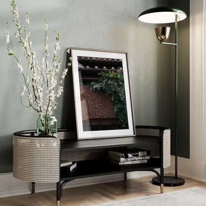 A stylish room featuring the Kagurazaka Essence floor lamp, a framed photo leaning on a table, and a vase with blooming branches.