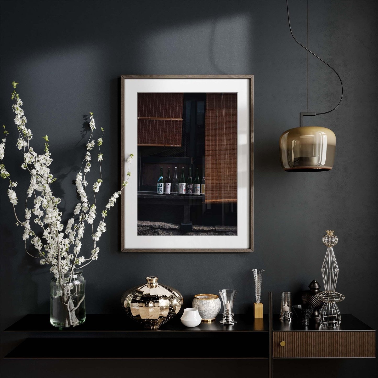 Elegant interior with a framed picture of Kagurazaka Sake picture, vase of flowers, and decorative objects on a dark shelf and wall.