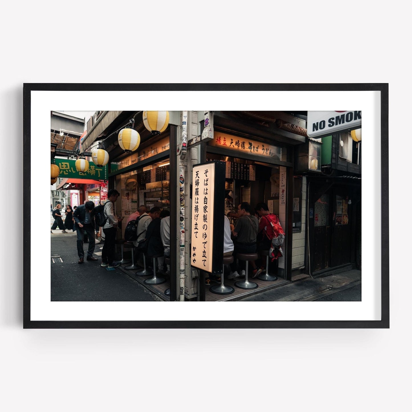 Customers enjoying their meals at Kameya Soba, a small noodle shop adorned with hanging lanterns and Japanese signs on a bustling street.