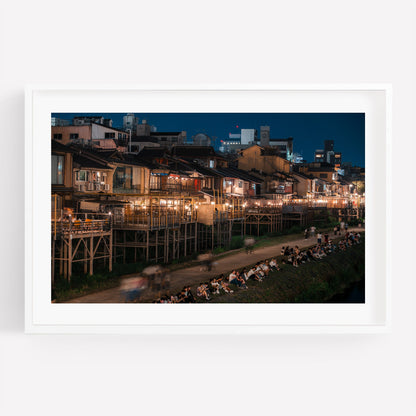 A framed photo titled Kamo River depicts a lively nighttime scene with people by the riverbank and illuminated buildings.