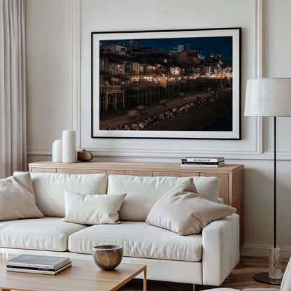 Living room with a white sofa, wooden cabinet, and a large framed Kamo River cityscape photo on the wall.