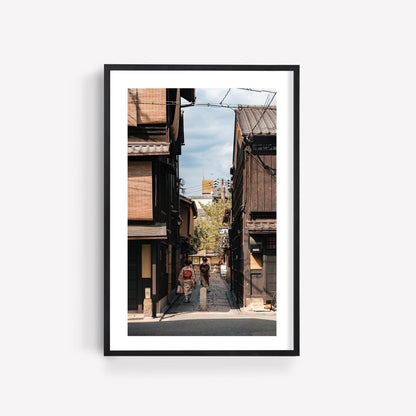 Framed photo titled Kimonos in Gion, featuring a traditional Japanese street with wooden buildings and pedestrians.