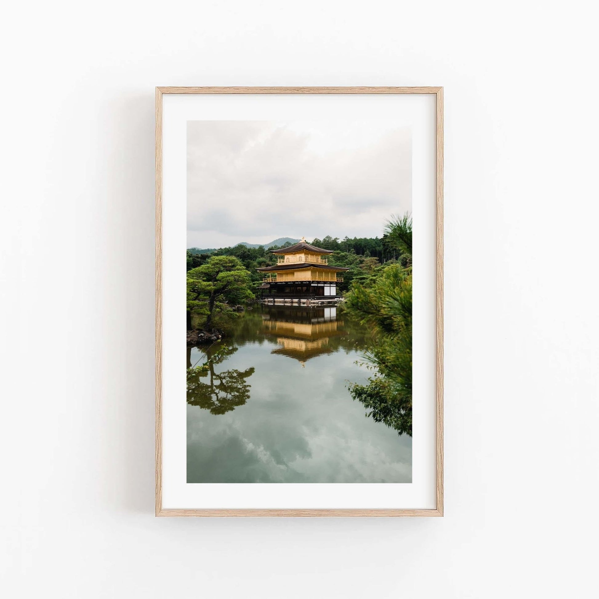 Framed photo of the Kinkaku-ji Temple surrounded by lush trees, beautifully reflected in calm waters.