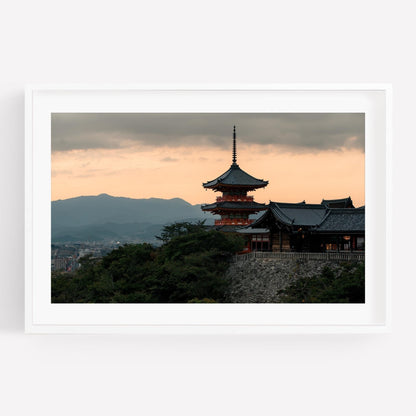 Framed photo titled Kiyomizu-dera Sunset II showcasing a Japanese temple silhouetted against a cloudy sky and distant mountains at sunset.